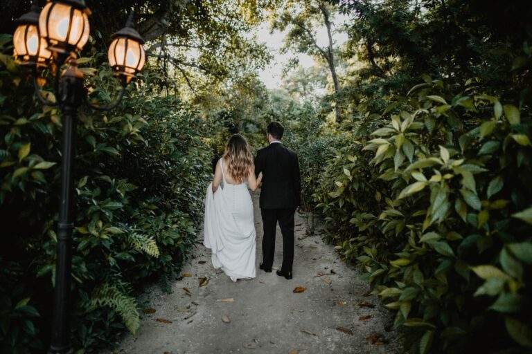 A bride and groom walk hand-in-hand.