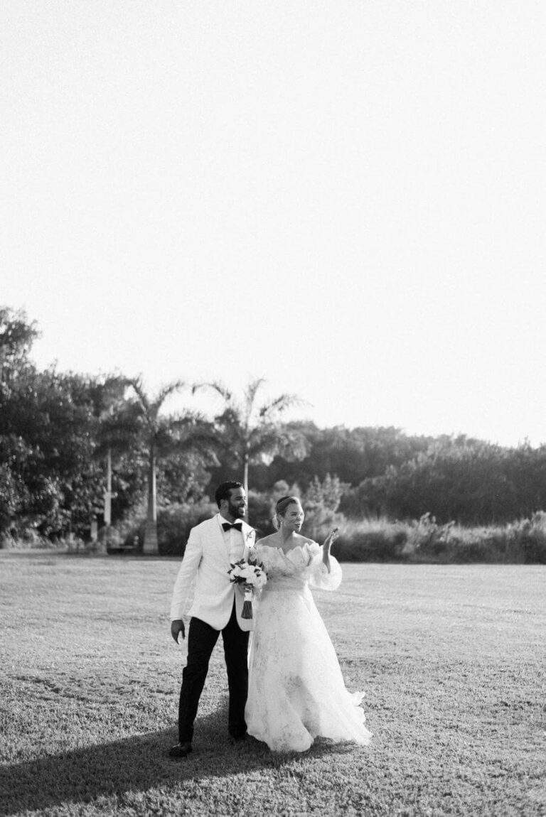 Couple at Deering Estate's Grand Waterfront Lawn with greenery in the background, edited in black and white