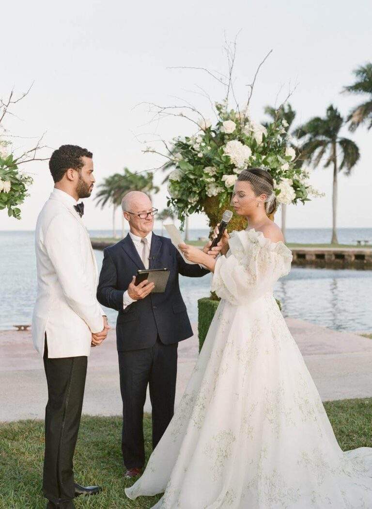Couple and officiant during the wedding ceremony at Deering Estate's Grand Waterfront Lawn