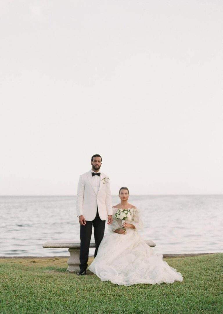 Couple at a bench at Deering Estate's Boat Basin on the south finger with views of Biscayne Bay in the background