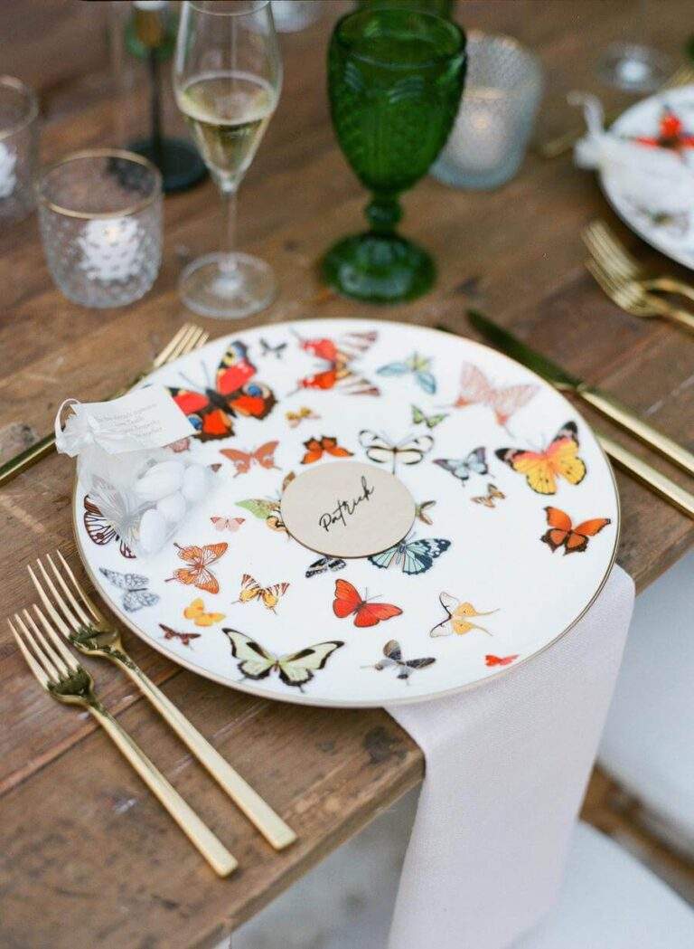 Reception table detail with a charger plate featuring different butterfly species at Deering Estate's Courtyard