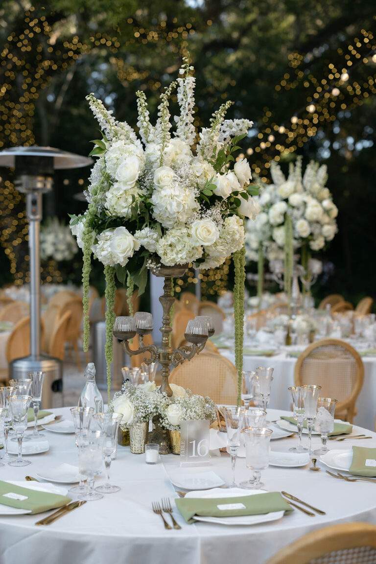 A table setting with large floral centerpiece for a wedding.